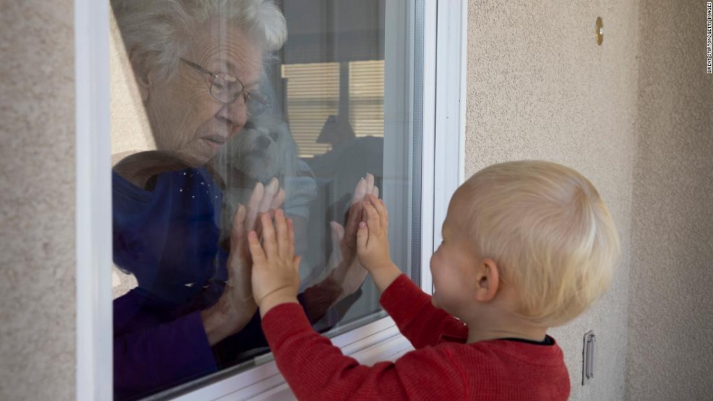 Cậu bé 2 tuổi ở California (Mỹ) trò chuyện với với hàng xóm qua cửa sổ, tháng 4/2020 (Ảnh: CNN)