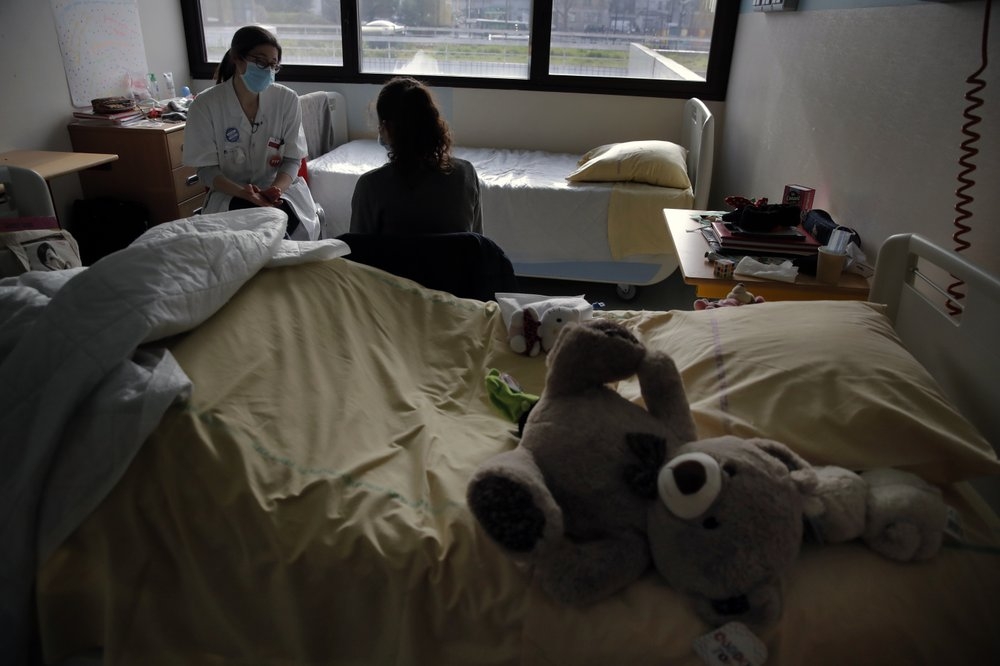 Bác sĩ Coline Stordeur nói chuyện với một bé gái tại khoa nhi của bệnh viện Robert Debre, ở Paris, Pháp (Ảnh: AP)