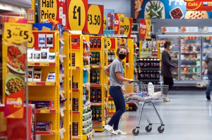 Người dân mua sắm hàng hóa trong một siêu thị tại Anh (Ảnh: Bloomberg)