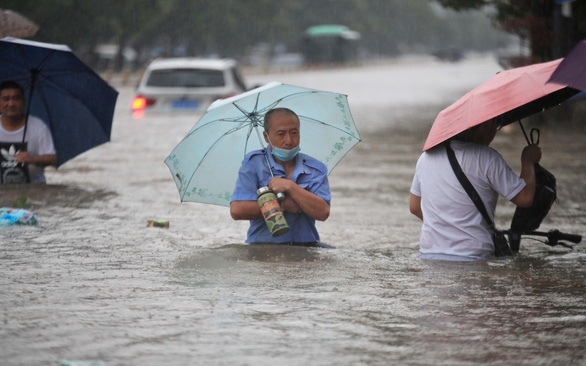 Nước lũ ngập ngang người tại Trịnh Châu, tỉnh Hà Nam ngày 20/7 (Ảnh: Reuters)