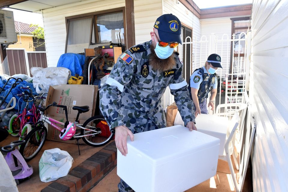 Binh sĩ và cảnh sát Australia đưa thực phẩm đến người dân trong khu vực phong tỏa (Ảnh: Reuters)