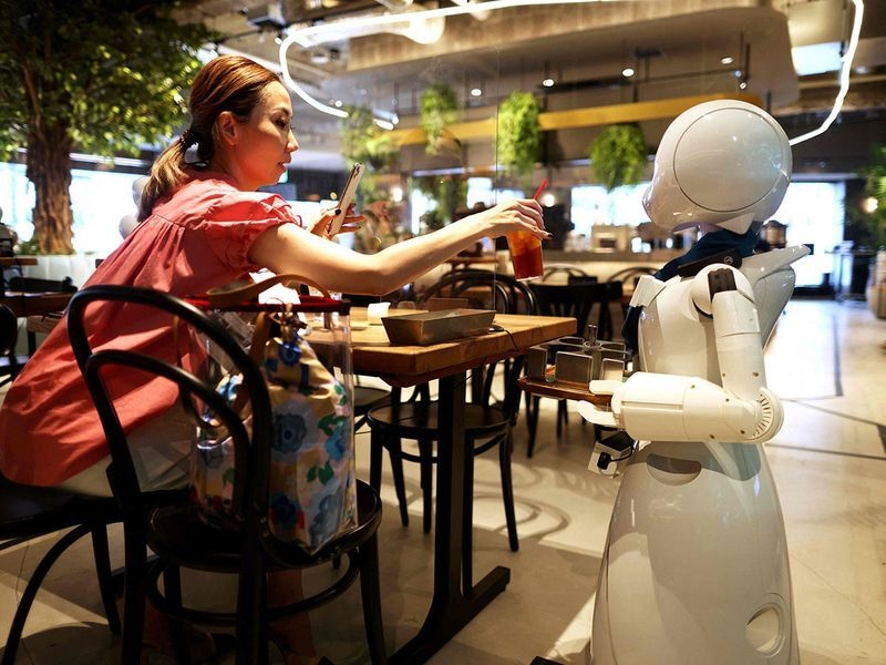 Những con robot lớn di chuyển xung quanh để phục vụ đồ uống hoặc chào đón khách hàng (Ảnh: AFP)