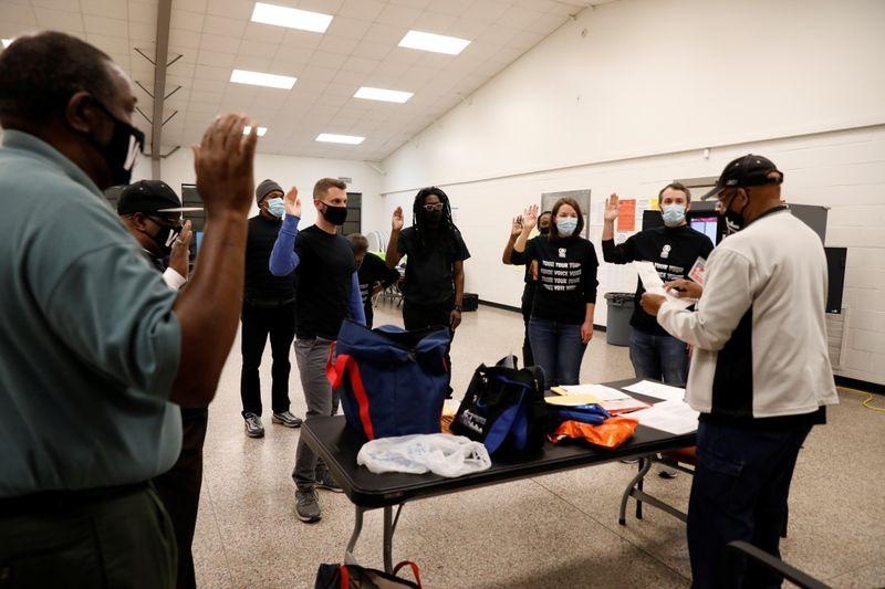 nhân viên tại điểm bỏ phiếu tuyên thệ trước khi nhận nhiệm vụ ở thành phố Atlanta, Georgia sáng 3/11 (Ảnh: Reuters).
