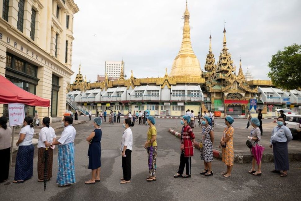 Những người đeo khẩu trang, đứng giãn cách tại một điểm bỏ phiếu ở Yangon, Myanmar, ngày 8/11/2020 (Ảnh: Reuters)