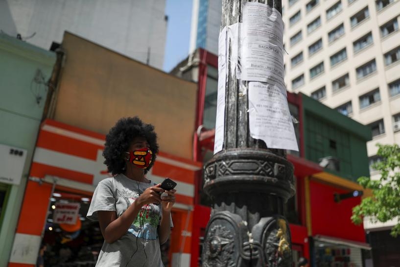 Một phụ nữ đang xem danh sách việc làm được dán trên cột đèn ở trung tâm thành phố Sao Paulo, Brazil (Ảnh: Reuters)