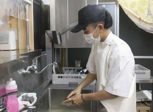 Sau giờ học, Lâm Nhật Hải làm thêm tại một nhà hàng ở Goto (Ảnh: Kyodo)