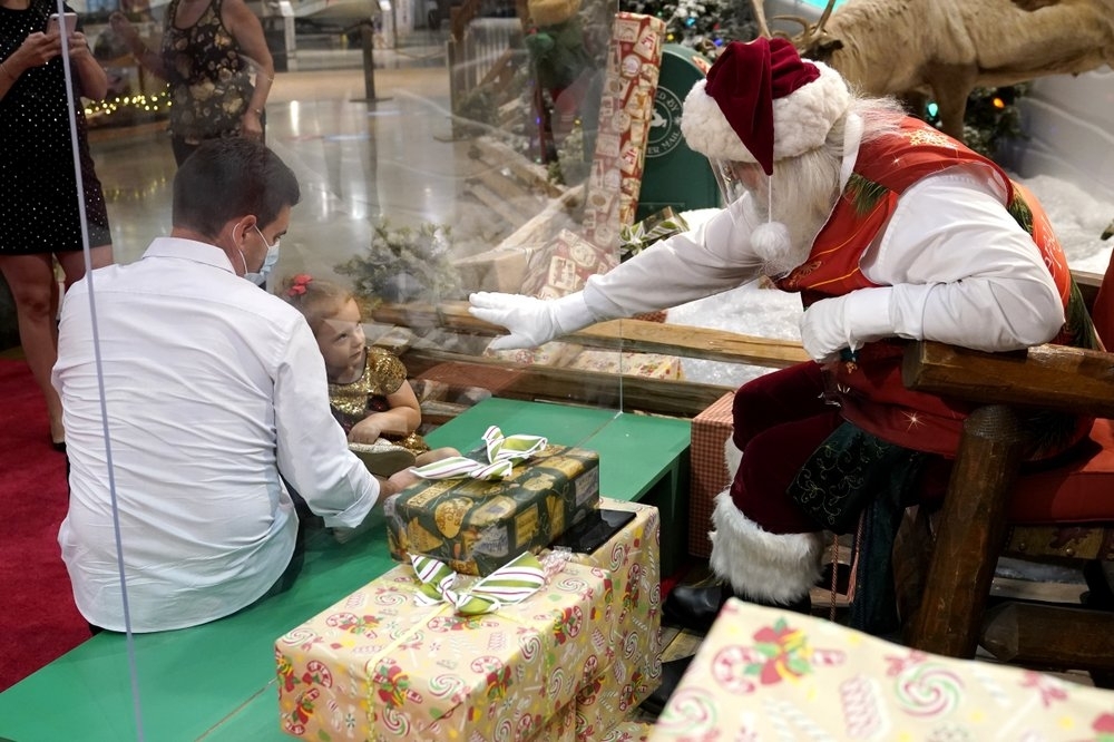 Ông già Noel ở thành phố Miami, Mỹ tương tác với trẻ em qua tấm chắn kính (Ảnh: AP) Ông già Noel ở thành phố Miami, Mỹ tương tác với trẻ em qua tấm chắn kính (Ảnh: AP)