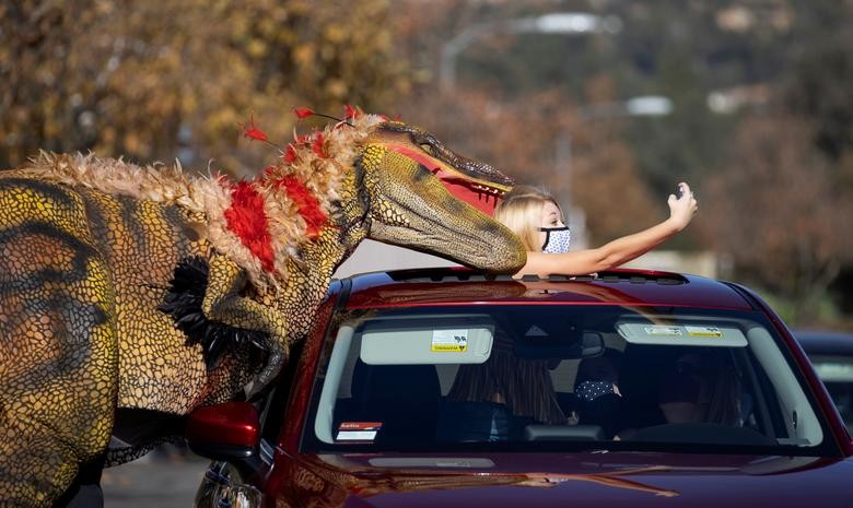 Một du khách đang sefie với nhân viên hoá trang thành khủng long ăn thịt tại triển lãm khủng lonh Jurassic Quest bên ngoài Sân vận động Rose Bowl ở Pasadena, California, ngày 15/1