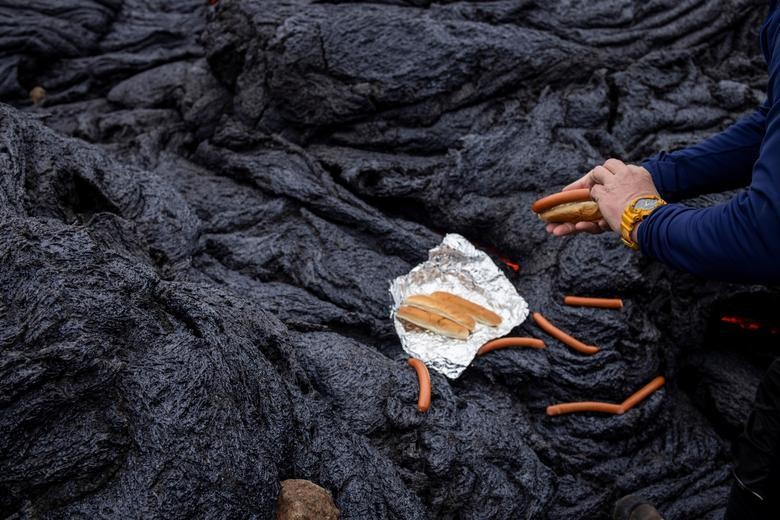 Một người đàn ông chuẩn bị nướng xúc xích sau khi núi lửa Fagradalsfjall (Iceland) phun trào ngày 21/3