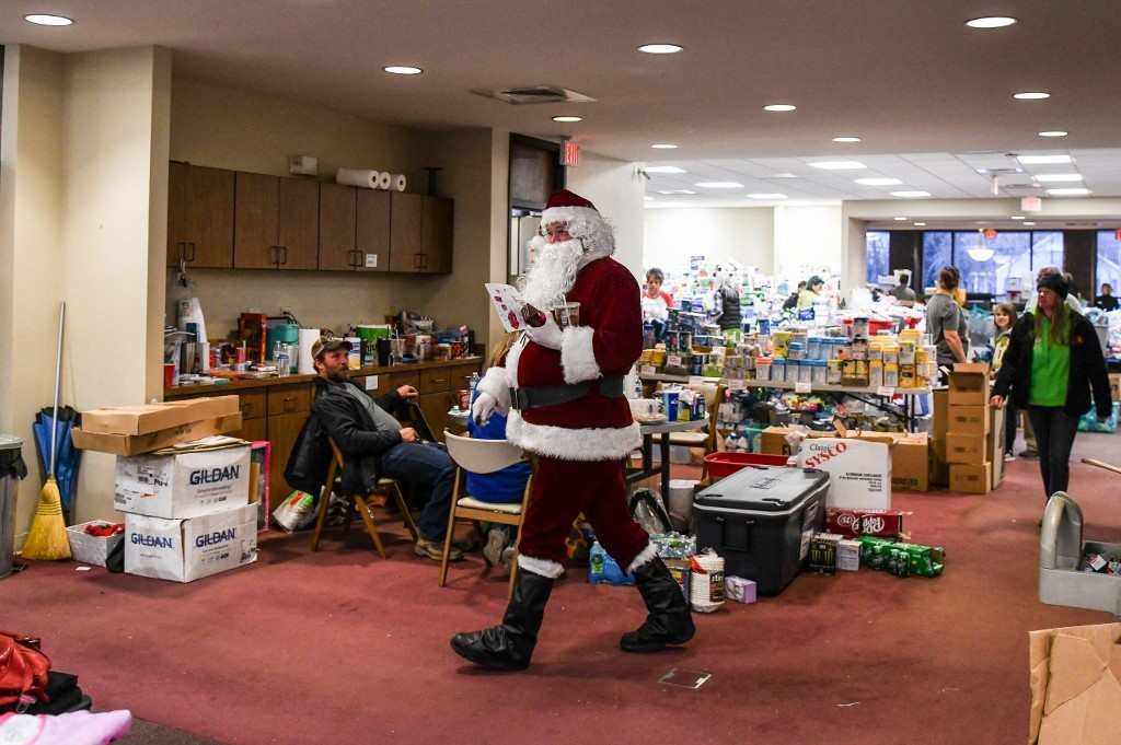 Một “ông già Noel làm việc trong khu quyên góp do câu lạc bộ Elks mở tại bang Kentucky, Mỹ. Những “Ông già Noel” này sẽ hỗ trợ hàng nghìn hộ gia đình ở Kentucky đang rơi vào khủng hoảng mùa Giáng sinh năm nay do lốc xoáy tàn phá (Ảnh: AFP)