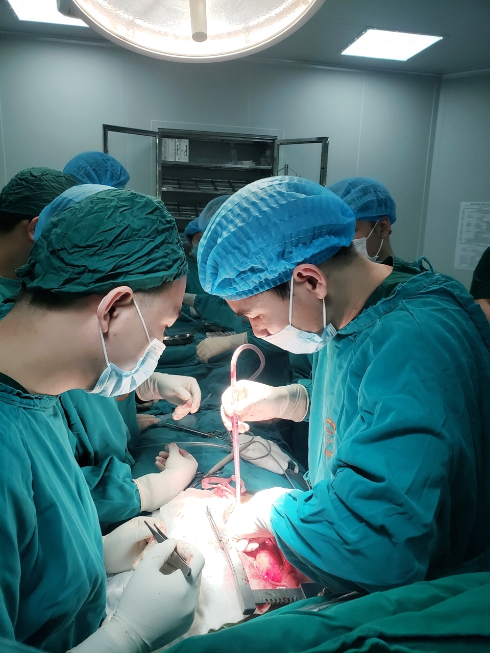 Bác sĩ Phạm Việt Hùng (bên phải), Trưởng khoa Ngoại, trưởng kíp phẫu thuật Tim hở, Bệnh viện Đa khoa tỉnh, phối hợp với các y, bác sĩ Bệnh viện Đa khoa khu vực Cẩm Phả phẫu thuật kịp thời cho người bệnh