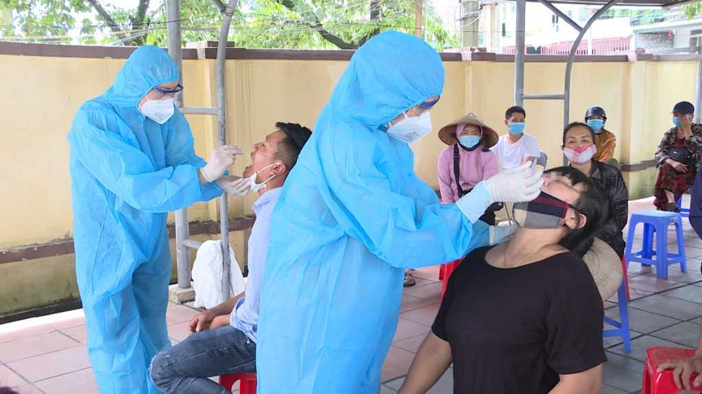 Nhân viên y tế lấy mẫu xét nghiệm cho người dân tại phường Mông Dương tháng 6/2021.