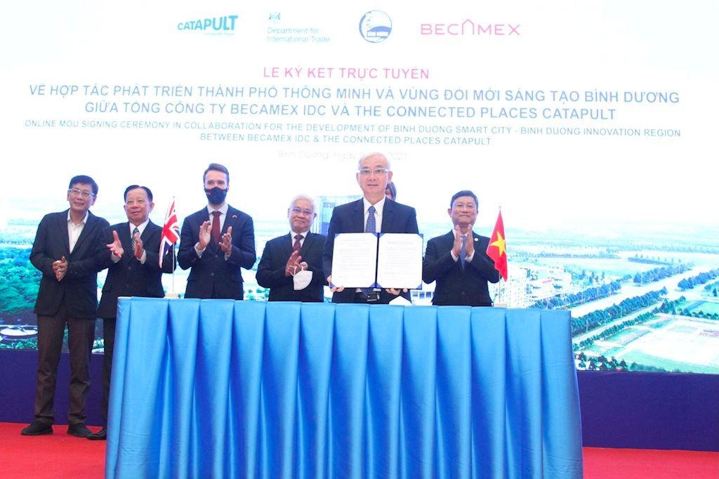 Các đại biểu thực hiện nghi thức ký kết hợp tác trực tuyến giữa Becamex IDC và The Connected Places Catapult tại điểm cầu Bình Dương, Việt Nam.