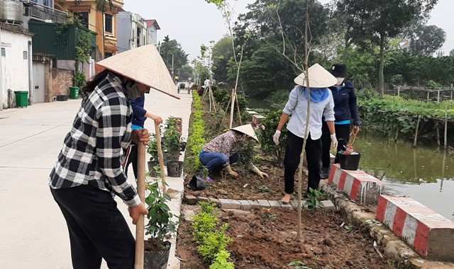 Người dân xã Tri Trung tham gia dọn dẹp vệ sinh môi trường và trồng tuyến đường hoa