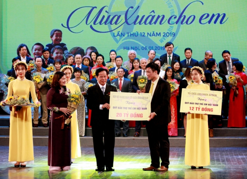 Ông Hoàng Văn Tiến – Giám đốc Quỹ Bảo trợ trẻ em Việt Nam (bên phải) tiếp nhận tài trợ tại chương trình và bà Nguyễn Thị Hà – Thứ trưởng Bộ Lao động – Thương binh và xã hội (bên trái) tặng hoa các nhà tài trợ