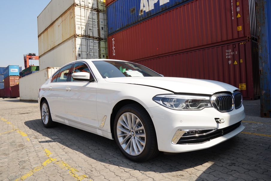 BMW 530i màu Alpine White xuất hiện tại cảng. Lưới tản nhiệt hình quả thận quen thuộc của BMW, được tích hợp hệ thống thông minh Active Air Vent Control, và đèn pha đôi tròn hai bên mang đến cho mặt trước của BMW Series 5 hoàn toàn mới vẻ ngoài bắt mắt hơn. Kính bọc đèn pha giờ đây được kết nối liền mạch với lưới tản nhiệt, giúp nhấn mạnh chiều rộng và sự liên kết trong thiết kế của chiếc xe.