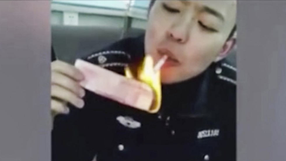 Đốt tiền để châm thuốc lá, 2 cán bộ thanh tra ở Trung Quốc bị sa thải