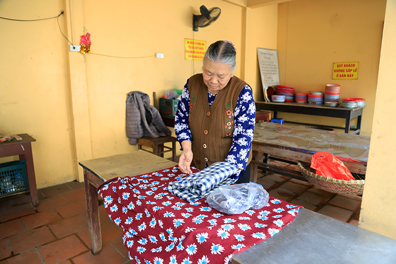 Thành viên Ban quản lý di tích phủ Tây Hồ sắp xếp khăn quấn, để phục vụ cho khách mặc chưa kín đáo vào Phủ.