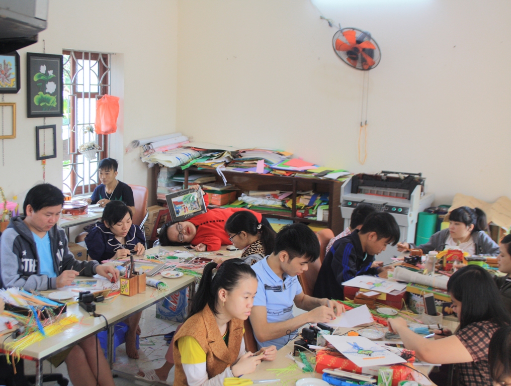 Chị Nguyễn Thị Thu Thương nằm trên bàn dạy nghề cho các em khuyết tật