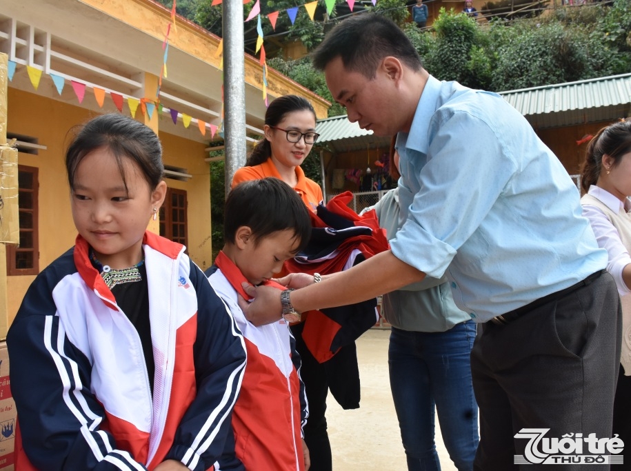 Đồng chí Ngô Vương Tuấn – Phó tổng biên tập báo Tuổi trẻ Thủ đô trao tặng áo ấm cho các em học sinh trường Phổ thông dân tộc bán trú Tiểu học Lao Chải, huyện Mù Cang Chải, Yên Bái
