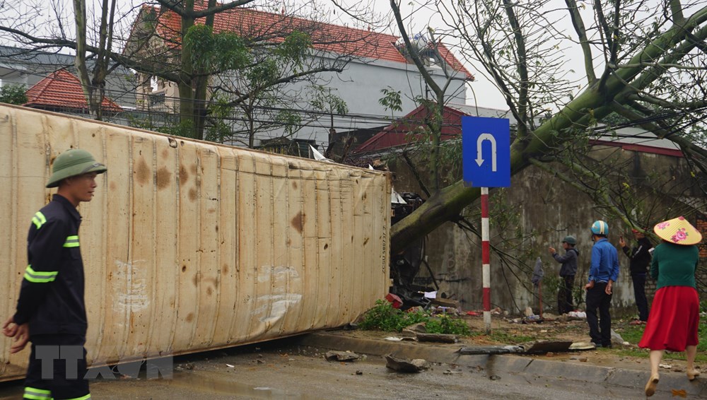 Xe container bị lật nghiêng, nằm chắn ngang làn đường ngược chiều khiến các phương tiện giao thông không thể đi qua làn đường này. (Nguồn: Khiếu Tư/TTXVN)
