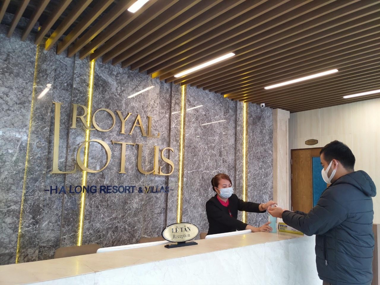 Nhân viên lễ tân của Royal Lotus Halong Resort &amp; Villas hướng dẫn và tiến hành vệ sinh khử trùng tay cho du khách