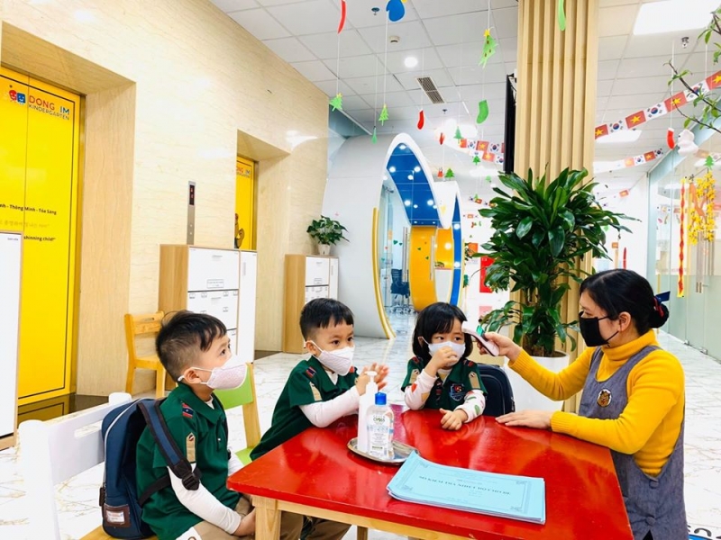 Giáo viên Trường mầm non Dongsim Kindergarten kiểm tra thân nhiệt và hướng dẫn học sinh vệ sinh phòng tránh dịch bệnh do virut Corona gây ra.