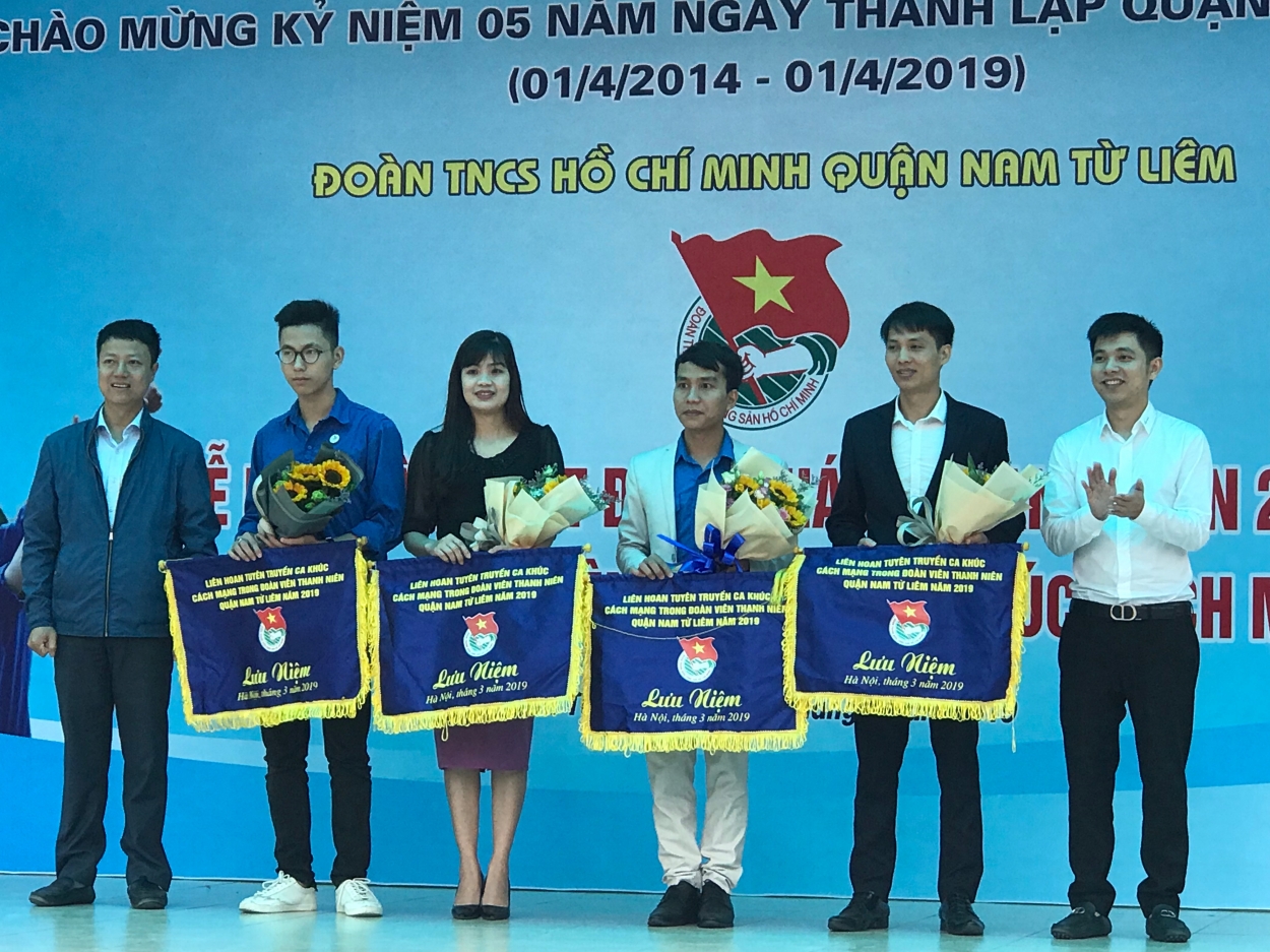 Đồng chí Nguyễn Mạnh Hùng – Quận ủy viên, Bí thư Quận đoàn, Chủ tịch Hội Liên hiệp Thanh niên quận Nam Từ Liêm (Ngoài cùng, bên trái) và Phó bí thư Quận đoàn trao cờ lưu niệm tới đại diện các đơn vị tham gia liên hoan tuyên truyền ca khúc cách mạng