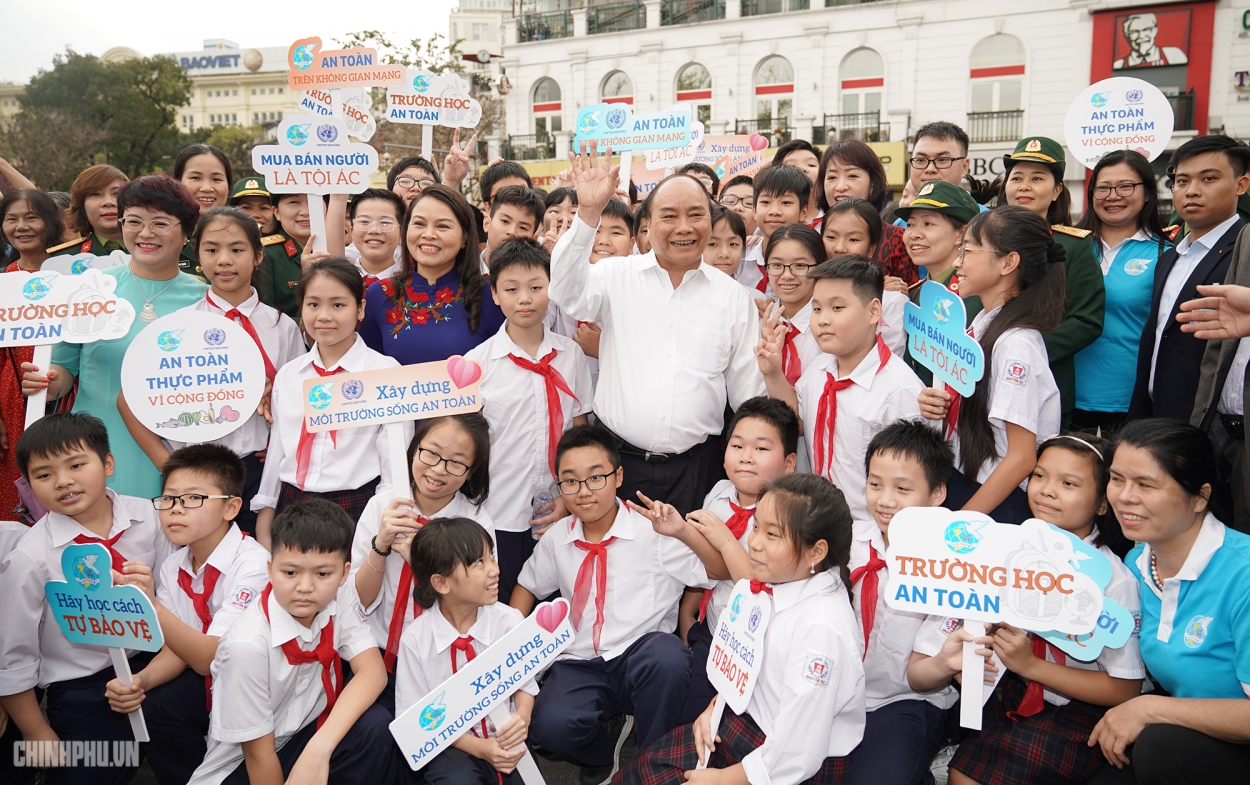 Thủ tướng thăm hỏi và chụp ảnh cùng trẻ em dọc tuyến đi bộ.