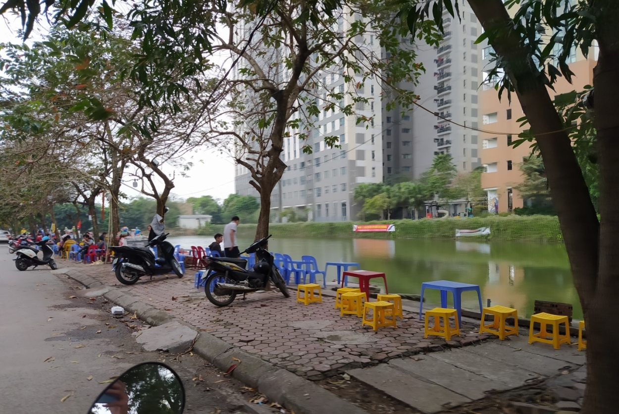 Nhiều người để xe trên vỉa hè, dưới lòng đường dọc hồ Mỗ Lao để ngồi uống nước
