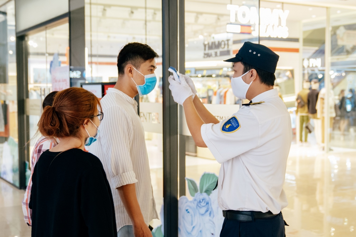 Nhân viên an ninh đo thân nhiệt toàn bộ khách ra vào TTTM để giảm thiểu nguy cơ lây nhiễm chéo