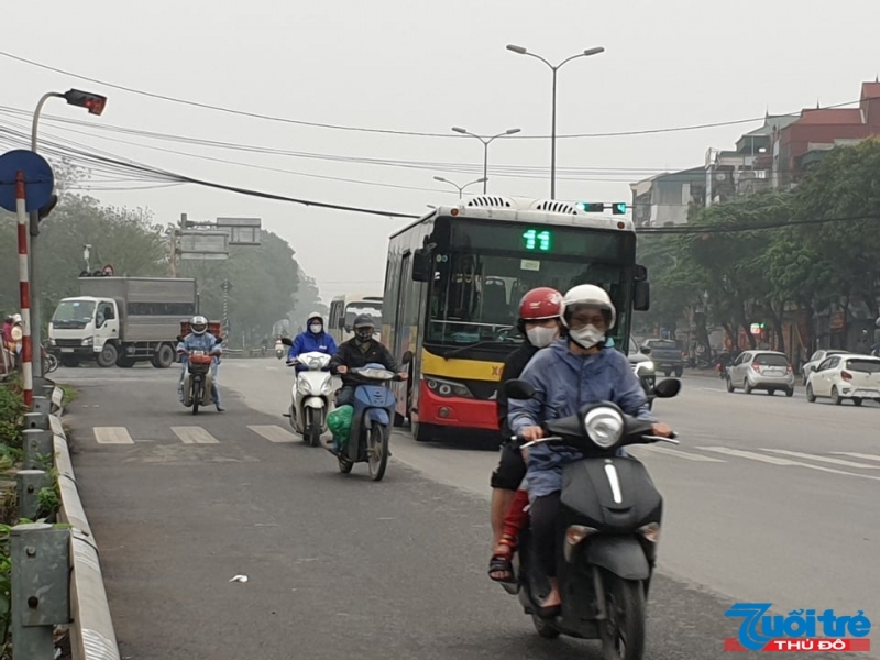 Người tham gia giao thông tại ngã tư Thạch Bàn - Vũ Xuân Thiều (Long Biên) chấp hành thông báo đeo khẩu trang bắt buộc