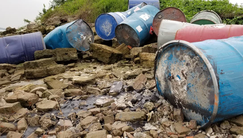 Một số thùng phuy đã bị rò rỉ chất đen ra bãi sông Hồng