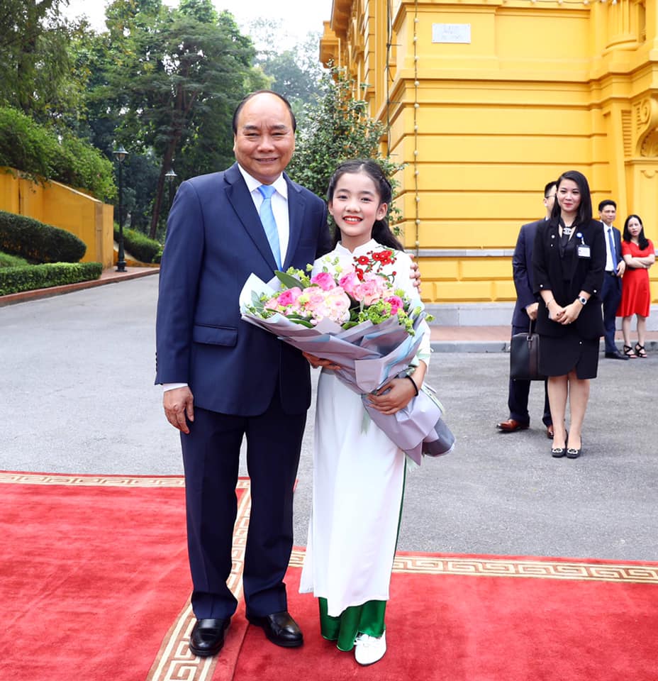 Em Nguyễn Lê Vi, học sinh lớp 6A3 vinh dự được tặng hoa cho Thủ tướng Nguyễn Xuân Phúc