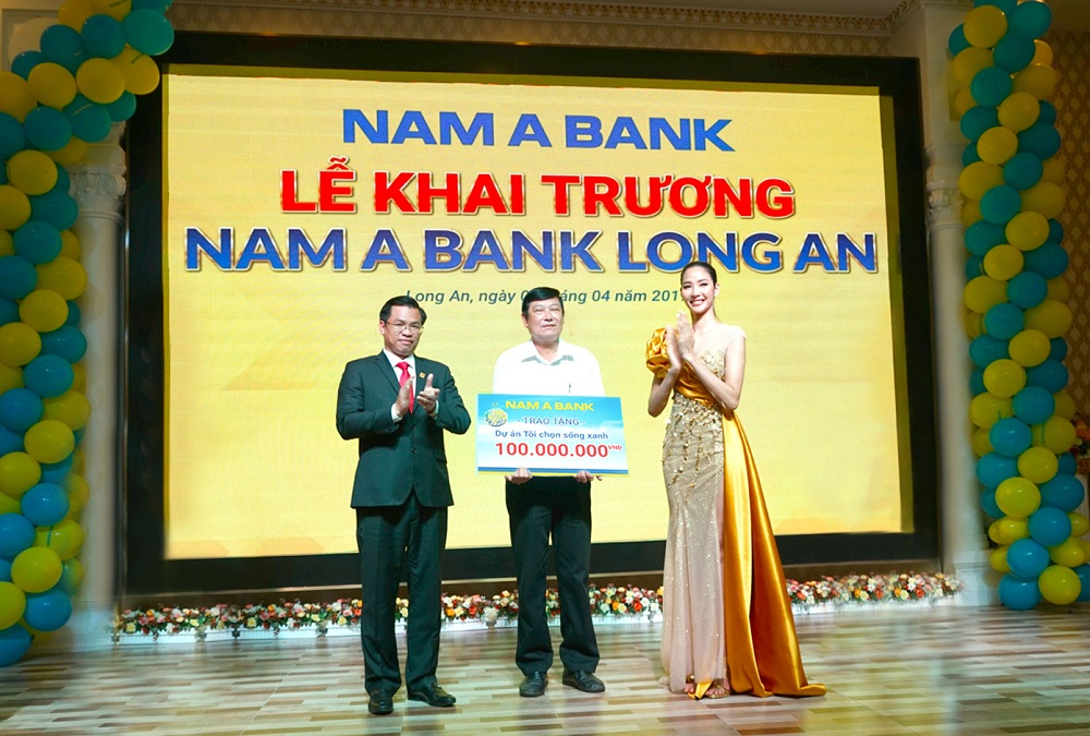 Ông Trần Ngọc Tâm – Tổng Giám đốc Nam A Bank cùng Á hậu Hoàng Thùy trao tặng bảng tượng trưng cam kết về việc triển khai hai dự án vì cộng đồng “Tôi chọn sống xanh” và “Nâng bước đến trường – Thắp sáng tương lai” cho ông Huỳnh Văn Nhịn – Phó chủ tịch UBND TP Tân An