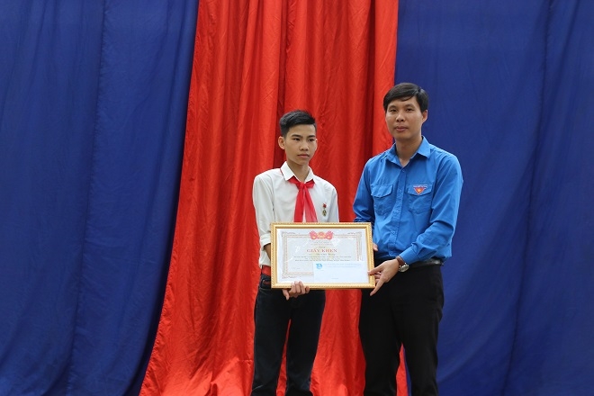 Đồng chí Nguyễn Hữu Tuất - Phó Bí thư Tỉnh đoàn, Chủ tịch Hội đồng Đội tỉnh Thanh Hóa tặng giấy khen cùng phần thưởng của Hội đồng đội tỉnh cho em Vũ Văn Hùng.