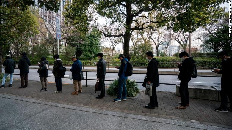 Những người đi làm chờ xếp hàng tại một trạm xe buýt vào ngày 26/3/2020 tại Tokyo, Nhật Bản