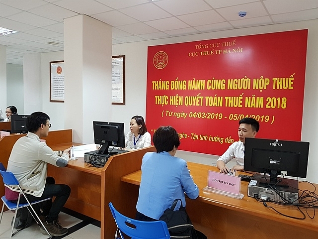 Cán bộ Cục thuế Hà Nội hướng dẫn người dân, doanh nghiệp hoàn thiện thủ tục nộp thuế