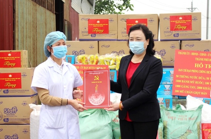 Đồng chí Ngô Thị Thanh Hằng, Ủy viên Trung ương Đảng, Phó Bí thư Thường trực Thành ủy Hà Nội, trao quà hỗ trợ Trạm Y tế xã Mê Linh.