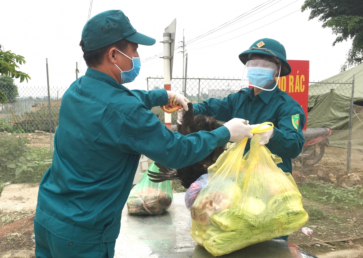 Lực lượng dân quân tự vệ vận chuyển lương thực cho người dân tại chốt cách ly