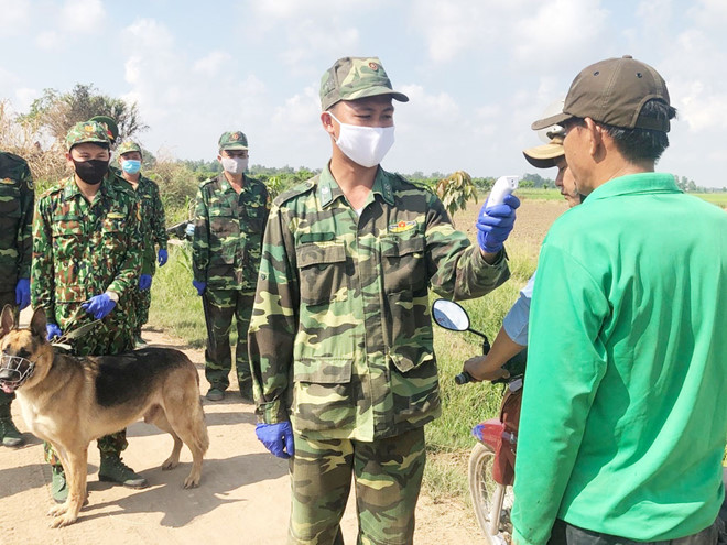 Các chiến sĩ Đồn biên phòng quốc tế Vĩnh Xương (An Giang) kiểm tra thân nhiệt người dân.