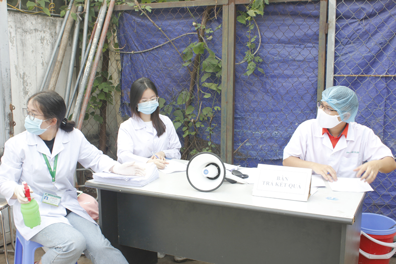 Lực lượng y tế tiếp đón, trả kết quả xét nghiệm Covid-19 cho bà con tiểu thương chợ Minh Khai