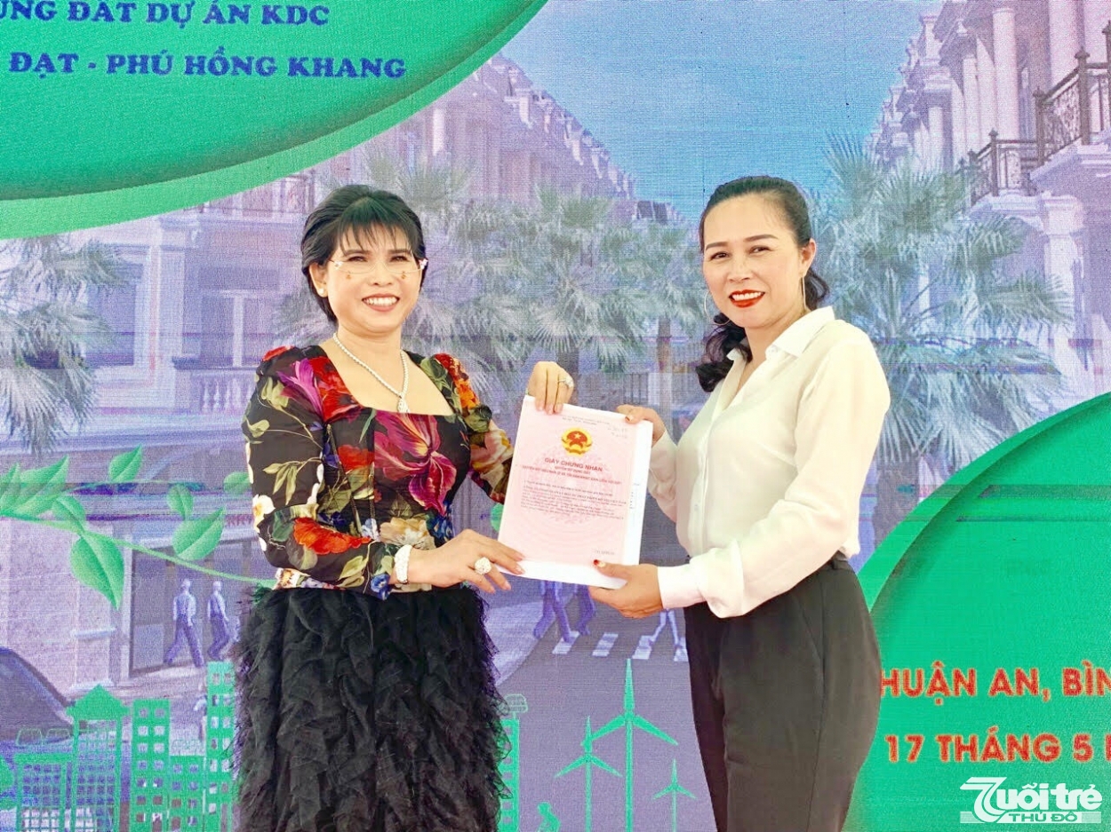 Bà Phạm Thị Hường, Chủ tịch HĐQT Phú Hồng Thịnh, Tổng Giám đốc Công ty Phát triển Đô thị Việt Nam trao sổ hồng cho cư dân.