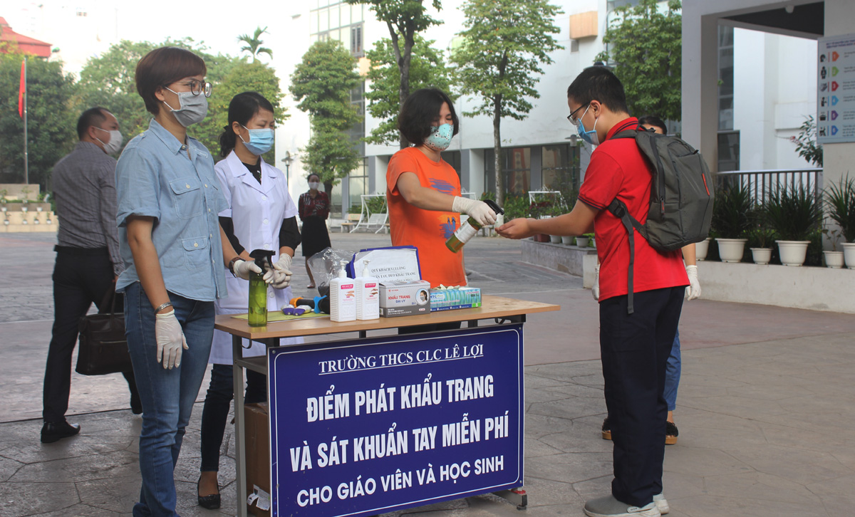 Sau khi đo thân nhiệt, các em học sinh được sát khuẩn tay trước khi vào lớp học