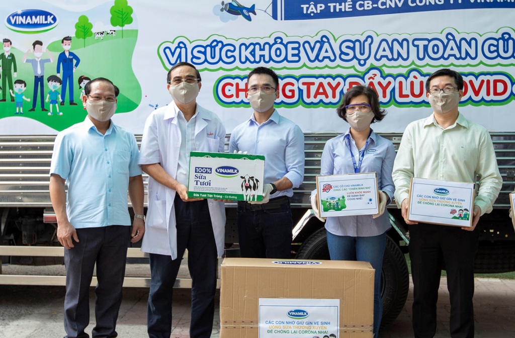 Anh Nguyễn Quang Thái (đứng giữa) đại diện công ty trao tặng sữa cho các trẻ em có hoàn cảnh khó khăn cần giúp đỡ trong dịch Covid-19 vừa qua