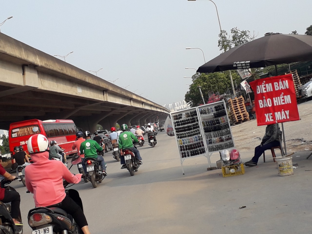 Người bán bảo hiểm trên đường Nguyễn Xiển dựng chỗ ngay dưới lòng đường để thu hút khách hàng