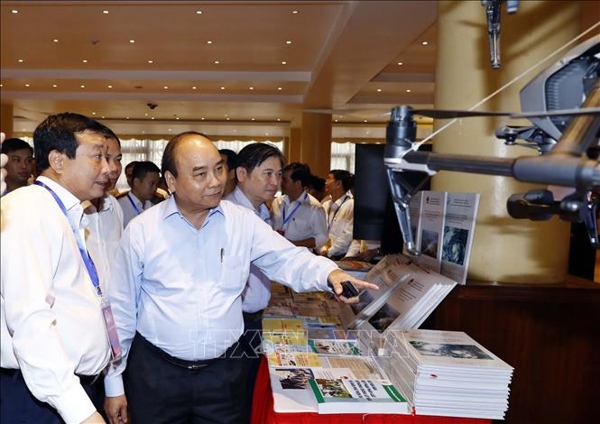 Thủ tướng Nguyễn Xuân Phúc và các đại biểu tham quan triển lãm công nghệ phòng chống thiên tai được trưng bày tại hội nghị. Ảnh: TTXVN