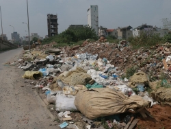 Vỉa hè đường gom đại lộ Thăng Long thành nơi tập kết rác thải