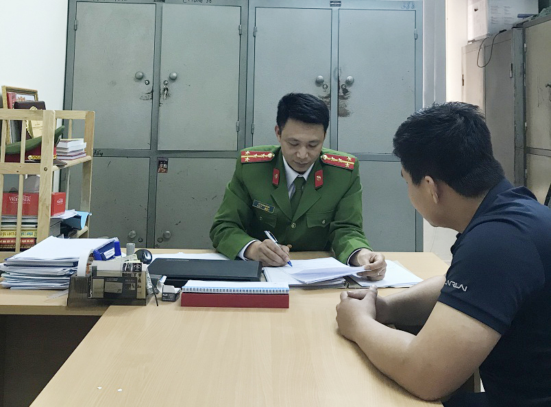 Thiếu tá Lê Thăng Bằng (người mặc cảnh phục) tại nơi làm việc