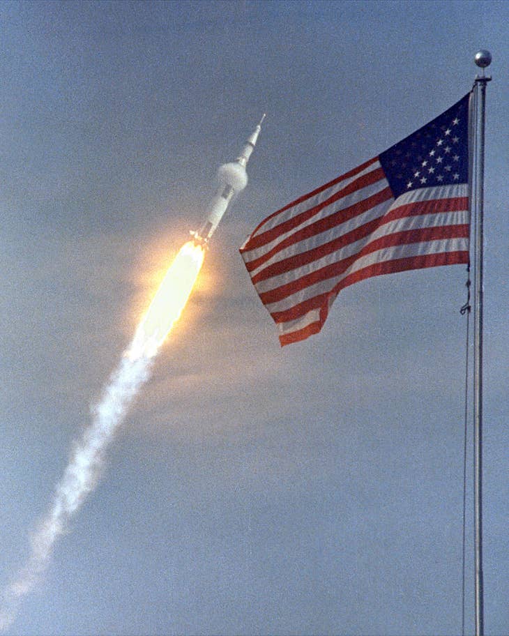 Quốc kỳ Mỹ tung bay khi tên lửa Saturn V vút lên không trung. Ảnh: NASA/EPA